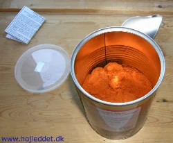 The tin is sealed with a pull-off metal tab and includes a plastic lid for resealing. Inside the tin is a manual explaining how to best use the food.